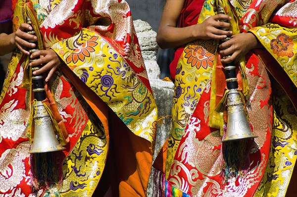 Bhutan, Bumthang District, Tamshing Lhakang, Buddhist pipe players dressed in ceremonial silk robes. 
Photo Nic I'Anson