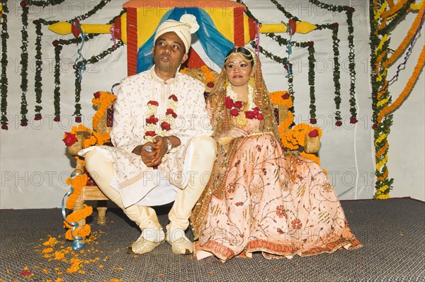 Bangladesh, Dahka, Bride and groom dressed up in glitzy jewellery and flowers for their wedding. 
Photo Nic I'Anson