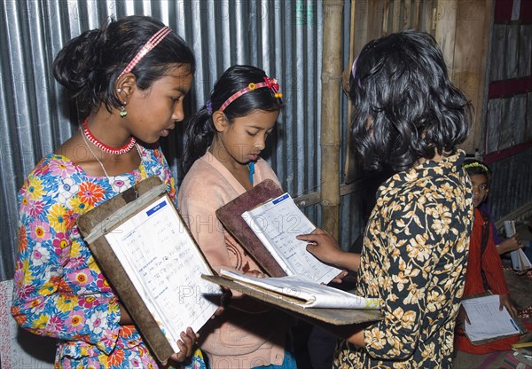 Bangladesh, Chittagong Division, Comilla, BRAC students in a primary classroom with peer marking. 
Photo Nic I'Anson