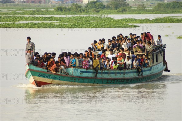 Bangladesh, Dhaka Division, Keraniganj Upazila, Overcrowded boat travelling down a tributary river. . 
Photo Nic I'Anson