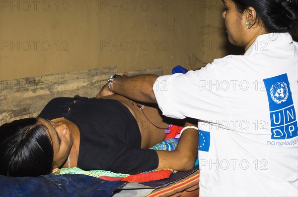 Bangladesh, Chittagong Division, Khagrachari, Pregnant mother being examined by UNDP nurse. 
Photo Nic I'Anson