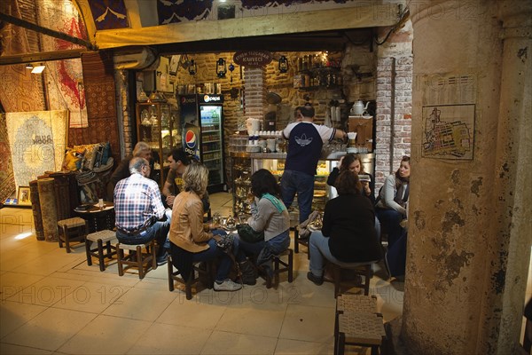 Turkey, Istanbul, Fatih, Sultanahmet, Kapalicarsi, Tourists sat at coffee shop in the Grand Bazaar. 
Photo Stephen Rafferty