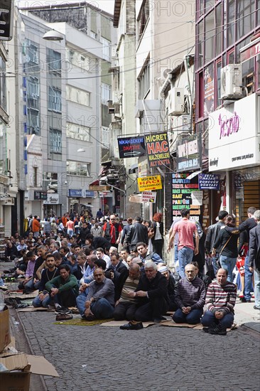 Turkey, Istanbul, Fatih, Sultanahmet, Men sat in street in readiness for midday prayers. 
Photo Stephen Rafferty