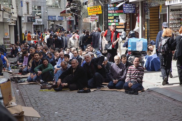 Turkey, Istanbul, Fatih, Sultanahmet, Men sat in street in readiness for midday prayers. 
Photo Stephen Rafferty