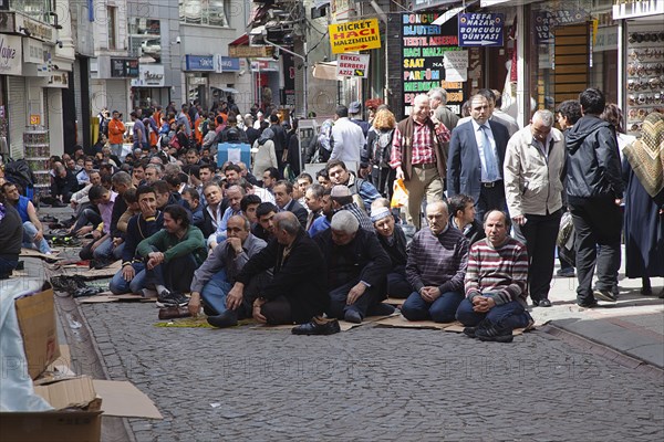 Turkey, Istanbul, Fatih, Sultanahmet, Men sat in street in readiness for midday prayers. 
Photo Stephen Rafferty