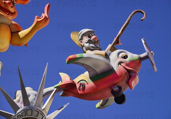 Spain, Valencia Province, Valencia, Papier Mache figure flying an airplane resembling a fish during Las Fallas festival. 
Photo Hugh Rooney