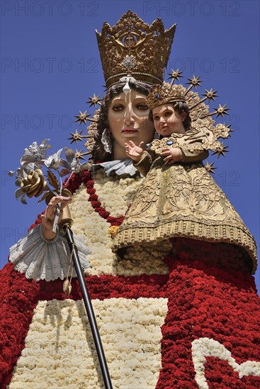 Spain, Valencia Province, Valencia, Statue of Virgen de los Desamparados, Our Lady of the Forsaken, decked out with flowers carried in the religious procession during Las Fallas festival. 
Photo Hugh Rooney