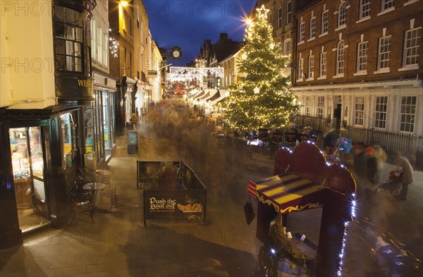 England, Hampshire, Winchester, High street decorated with Christmas tree and decorations, seen from the Buttercross.