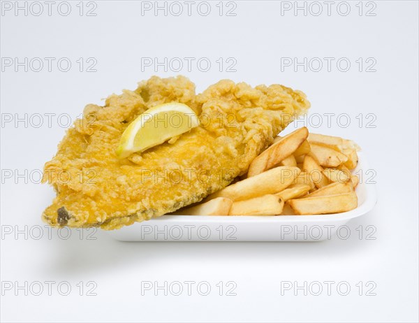 Food, Cooked, Fish, A portion of battered deep fried plaice with a slice of lemon and potato chips.