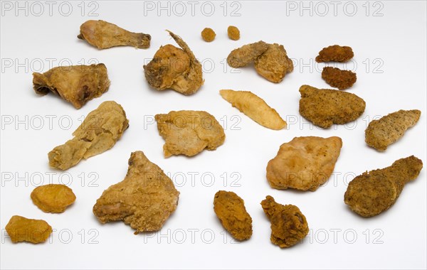 Food, Cooked, Poultry, Display of various battered and breaded fried portions of chicken on a white background.