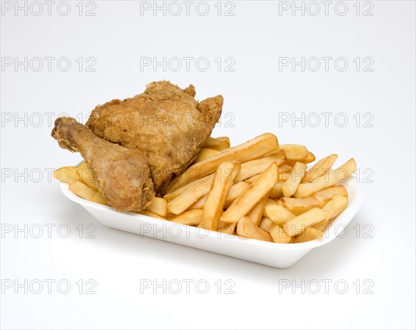 Food, Cooked, Poultry, Battered chicken breast fillet and drumstick with potato chips in a polystyrene foam tray on a white background.