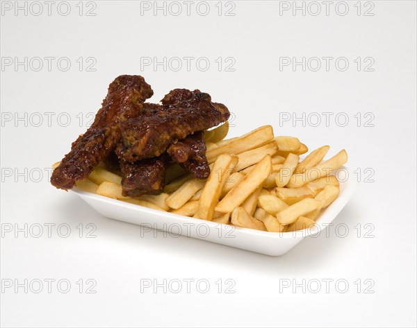 Food, Cooked, Meat, Sticky pork ribs with potato chips in a polystyrene foam tray on a white background.