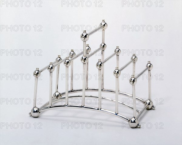 Toast rack; electroplated nickel silver; left 3/4 view; probably designed by Christopher Dresser (1834 - 1904); made by Hukin & Heath of Birmingham; English (Birmingham); c.1880.