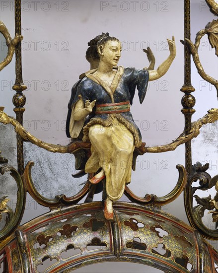 Statuette vernie surmontant un cadre de miroir