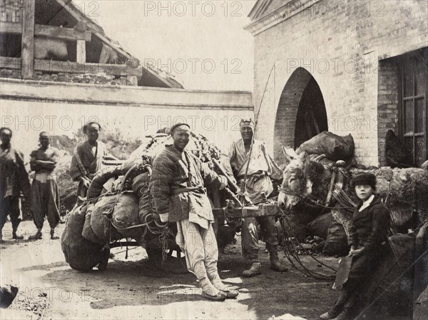 Chine, Pékin. Assistant du photographe et porteurs chinois