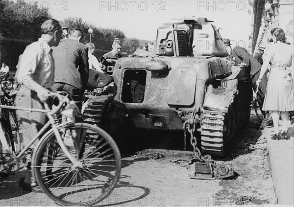 Un véhicule blindé détruit, dans les rues de Paris, lors de la Libération (août 1944)