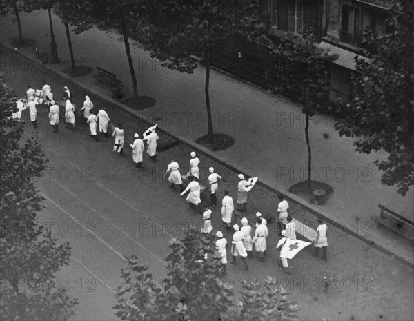 Groupe de brancardiers de la Croix-Rouge se rendant sur les lieux du combat, lors de l'insurrection de Paris (août 1944)