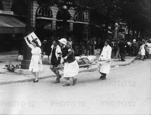 Strecher-bearers from the Red Cross heading towards the fights, during the Paris uprising (August 1944)