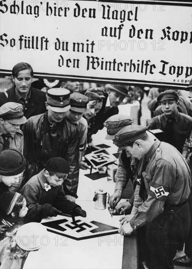 Stand où un jeune garçon s'exerce à un jeu datant de la première Guerre mondiale (1933)