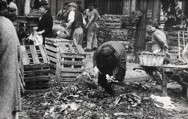 Femme ramassant les ordures laissées par le marché