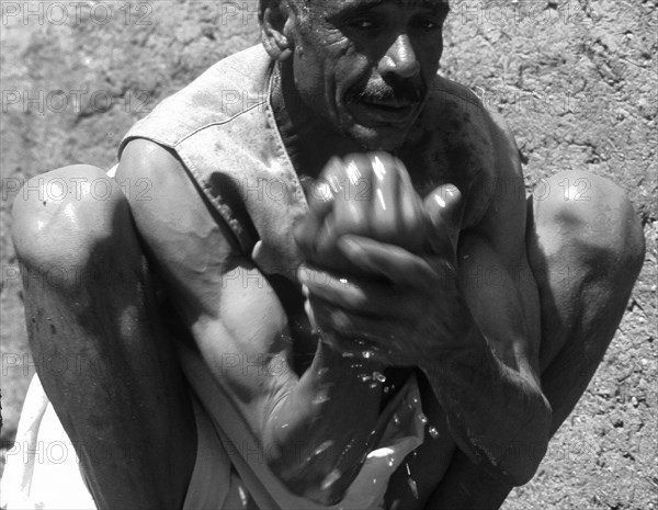 Homme se lavant dans la rivière, près de la vieille ville de Gurna, Egypte.